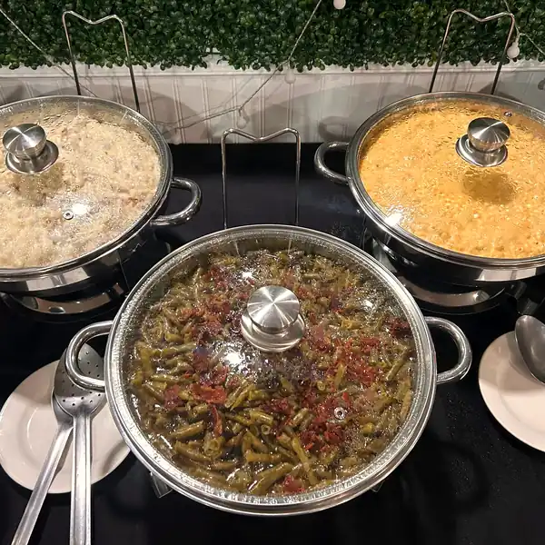 Chafing dishes of green beans, corn and mashed potatoes