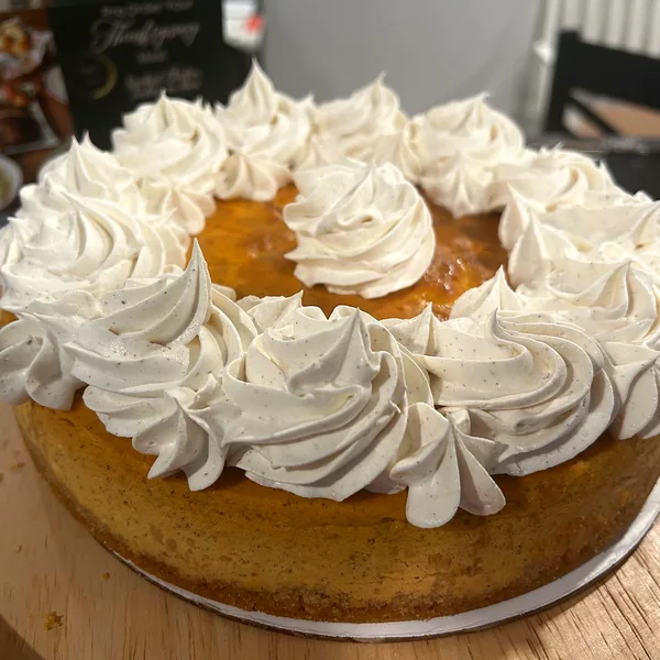 A cake topped with swirls of whipped cream