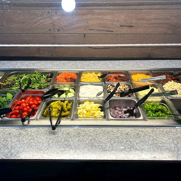 The salad bar stocked with fresh greens and toppings